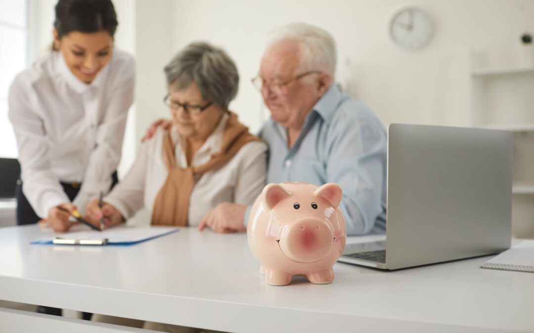 Happy retired senior couple sign life insurance paper at table in brokers office